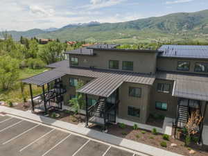 Modern multi-story building featuring dark siding and black metal roofs