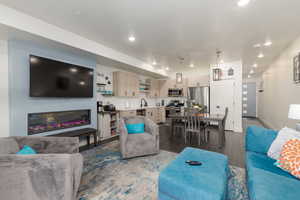 Open-concept living space featuring an electric fireplace and recessed lighting