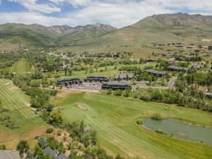 Expansive golf course property featuring green fairways, a natural pond, and mature landscaping