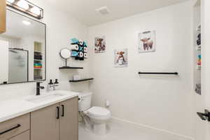 Bathroom featuring a vanity with light-toned cabinetry, a white countertop, and matte black hardware