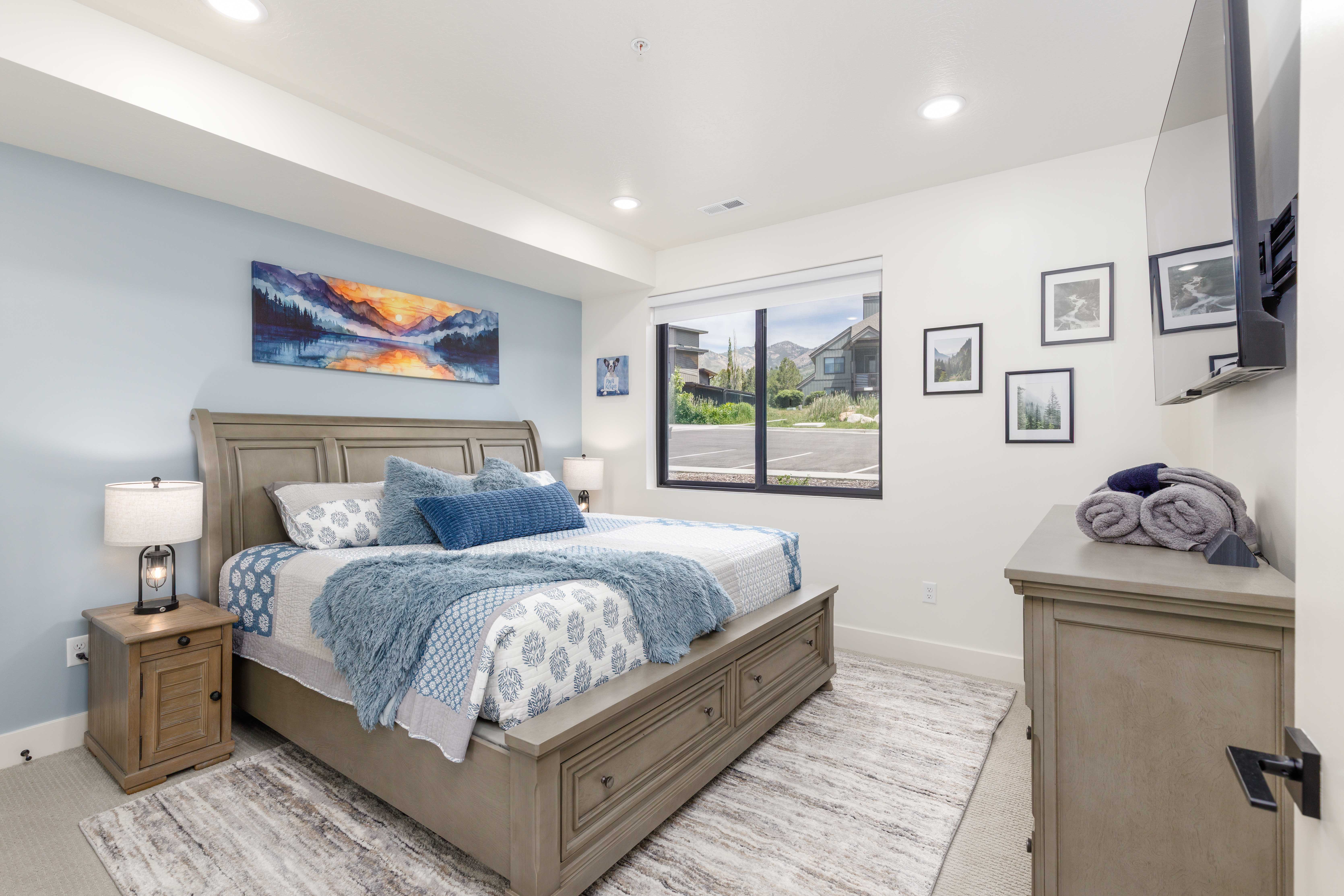 Spacious bedroom featuring light-colored carpeting, recessed lighting, and a large window with black framing