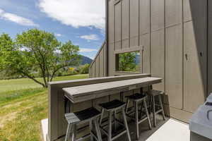Outdoor bar area featuring a pass-through window and a composite countertop