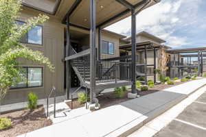 Modern multi-level building with tan horizontal siding and dark trim