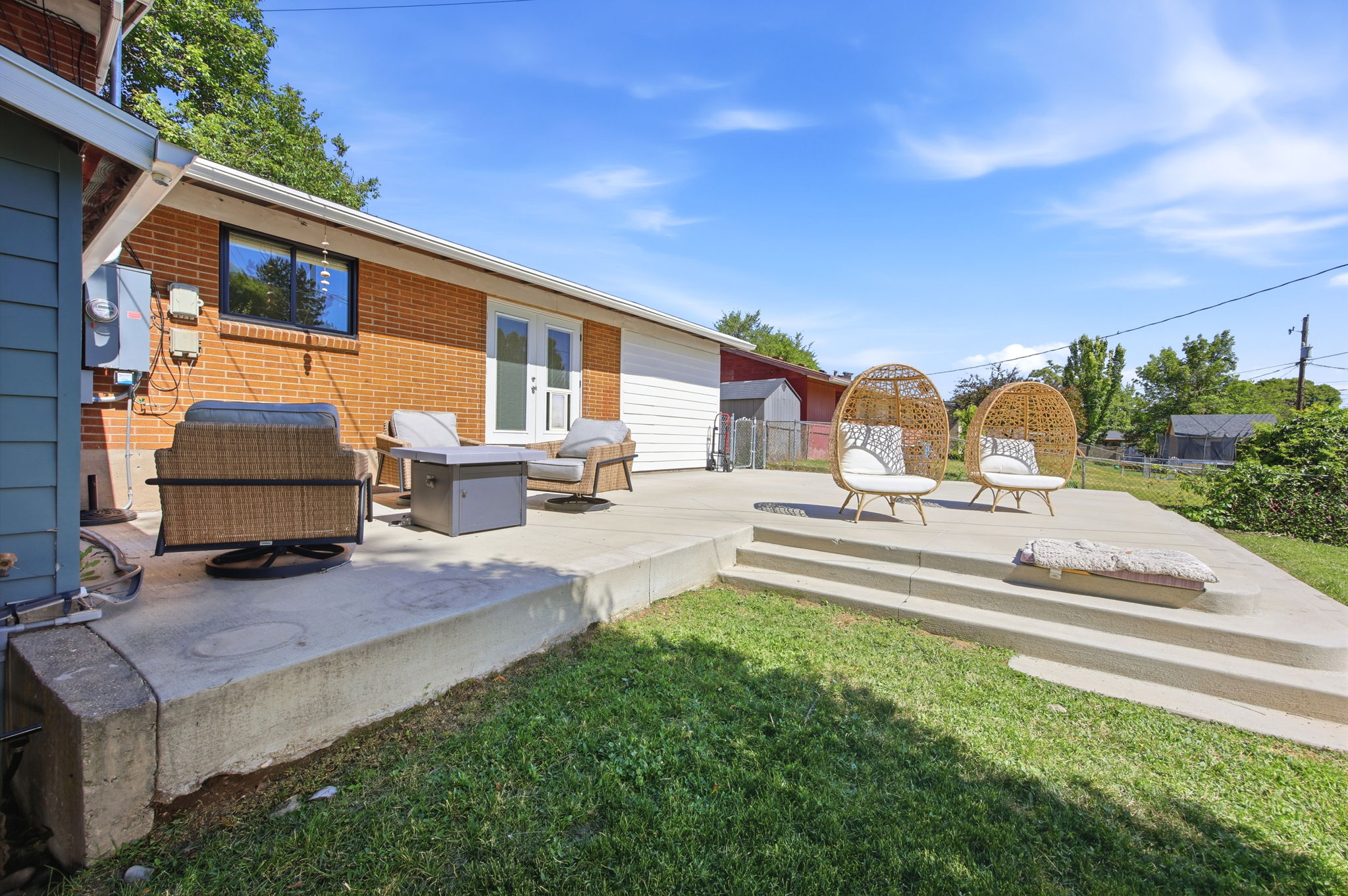 Expansive multi-level concrete patio with direct access to the interior via double French doors