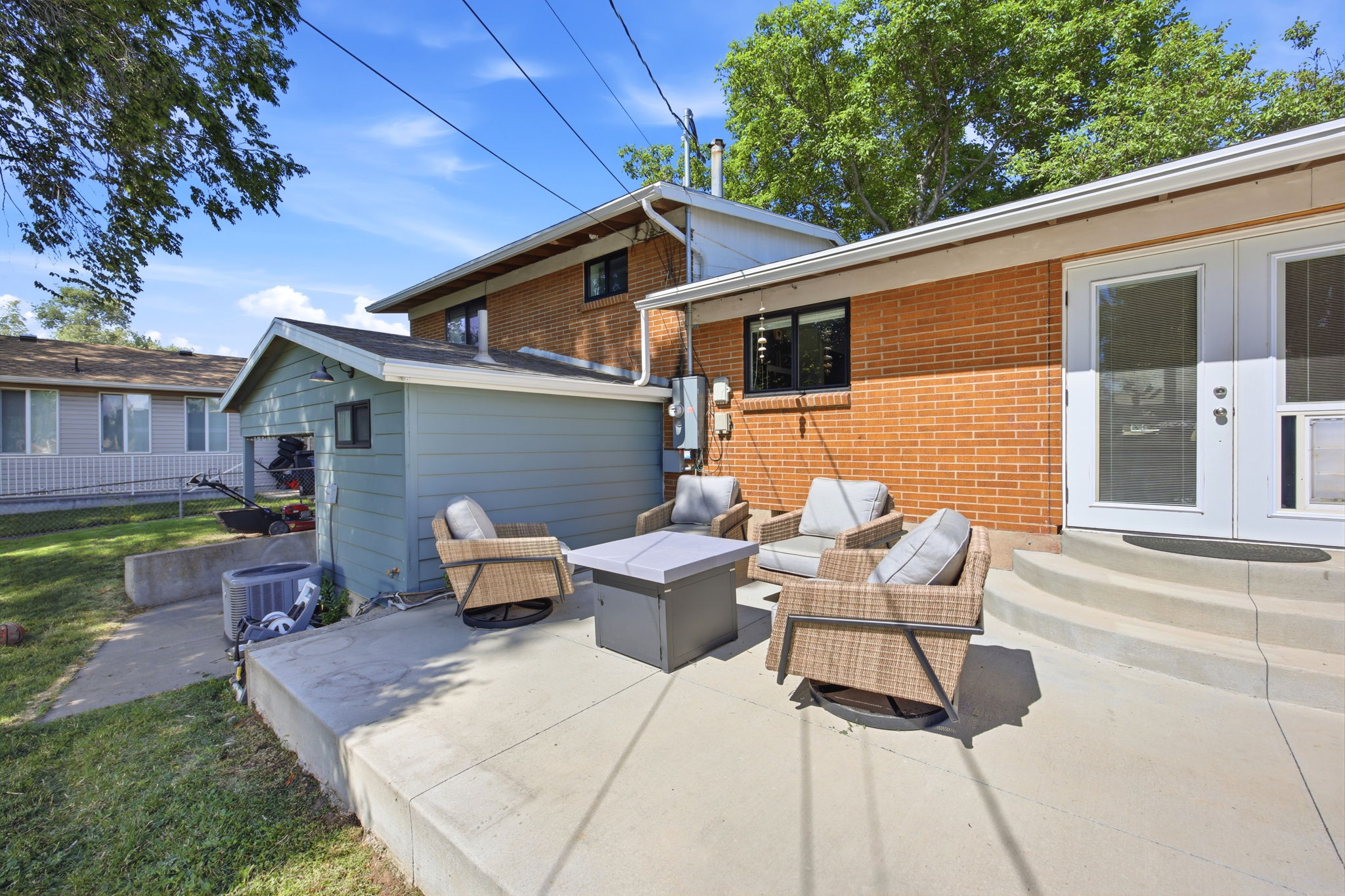 Rear concrete patio with a brick exterior and white French doors