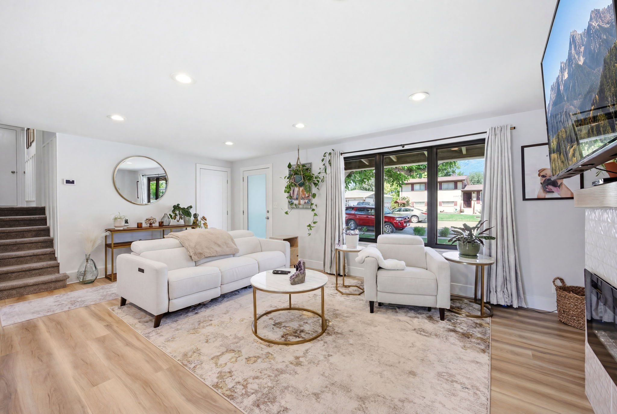 Open-concept living area featuring light wood-finish flooring, recessed lighting, and a neutral color palette