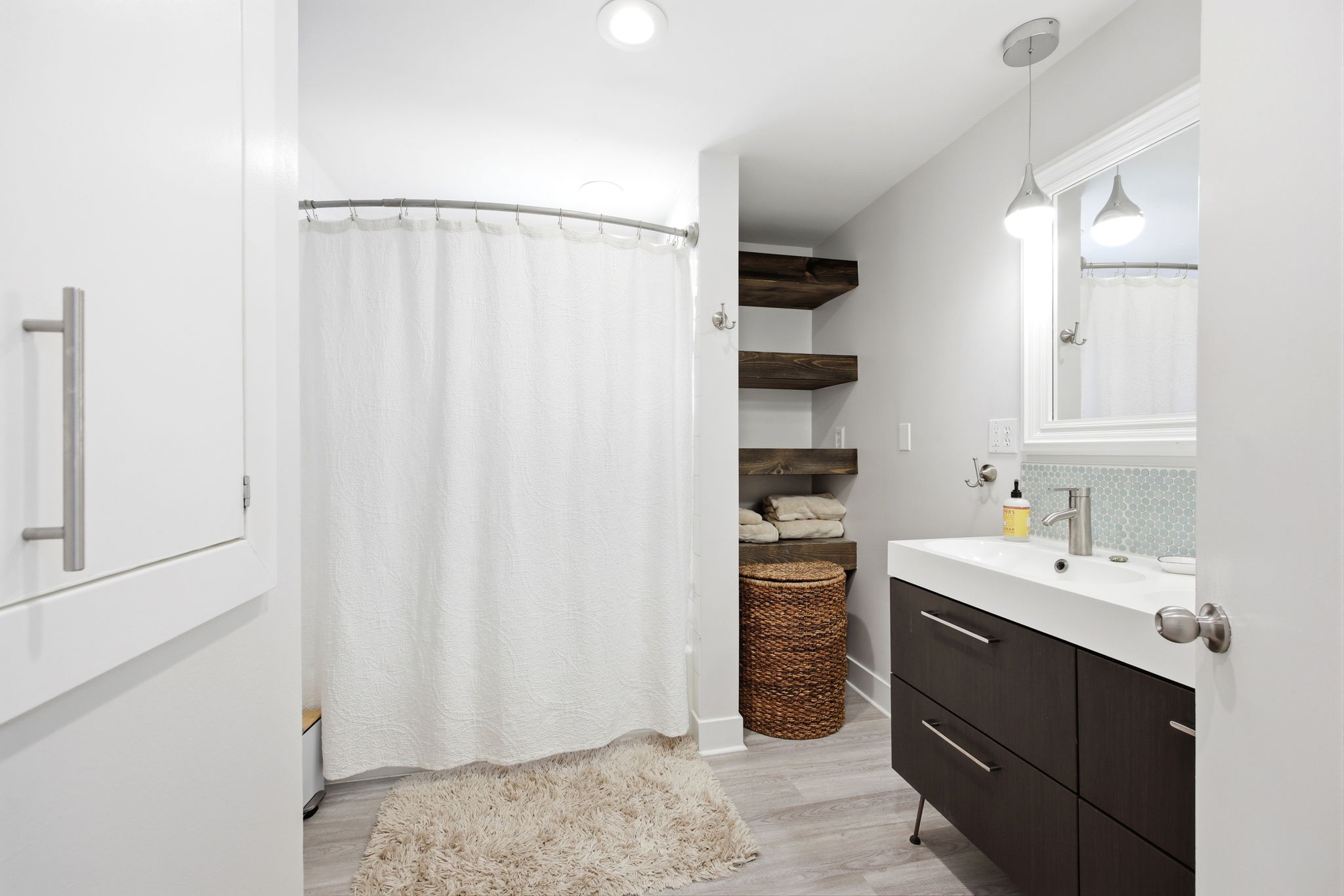 Modern bathroom featuring a dark wood-finish vanity with integrated sink, a tiled backsplash, and recessed lighting