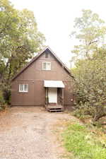 Brown exterior siding with a contrasting white front entry door and corrugated metal awning