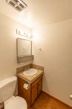 Powder room featuring a wood-finish vanity with a drop-in sink, tiled countertop, and matching tiled backsplash