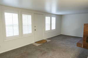 Living area featuring neutral-toned carpeting and white wall finishes