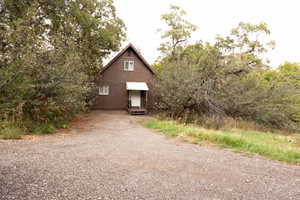Brown exterior siding home with a white entrance door, covered by a white awning