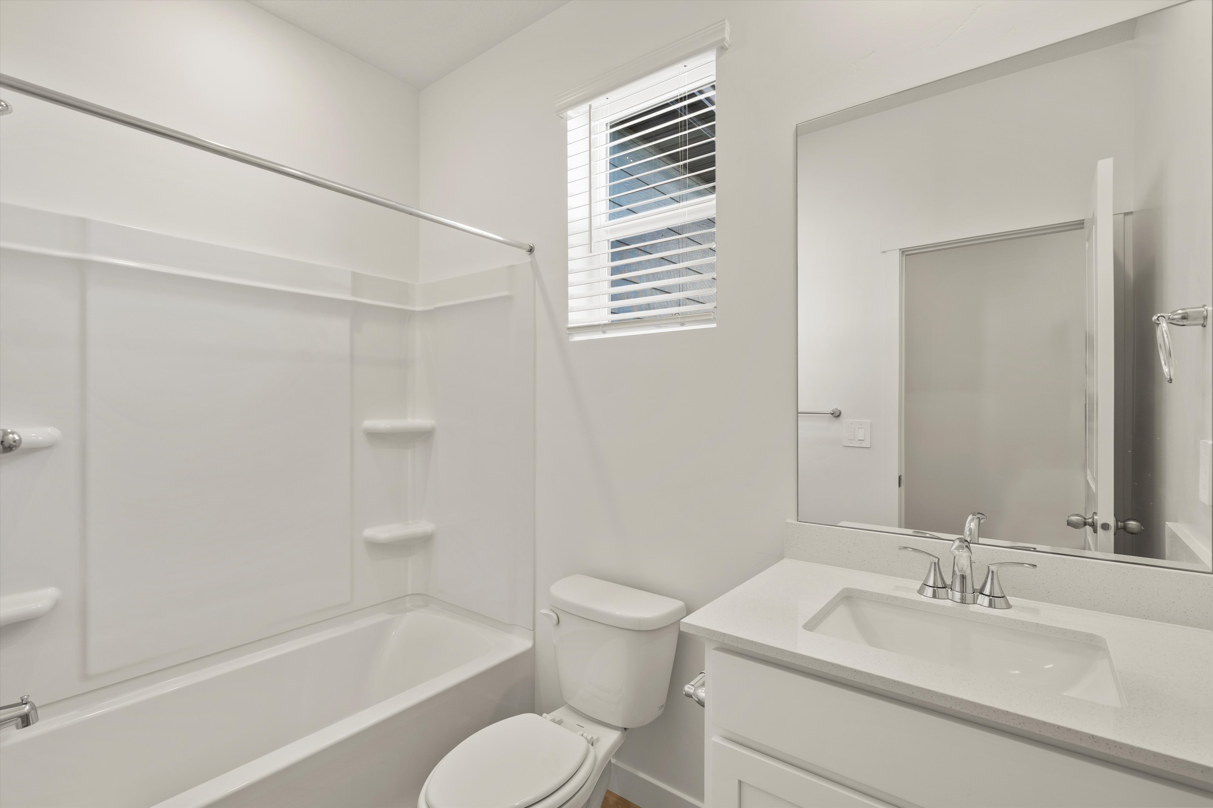 **DISCLAIMER** Interior package may vary. Bathroom featuring a white vanity with an integrated rectangular sink, chrome fixtures, and a large mirror