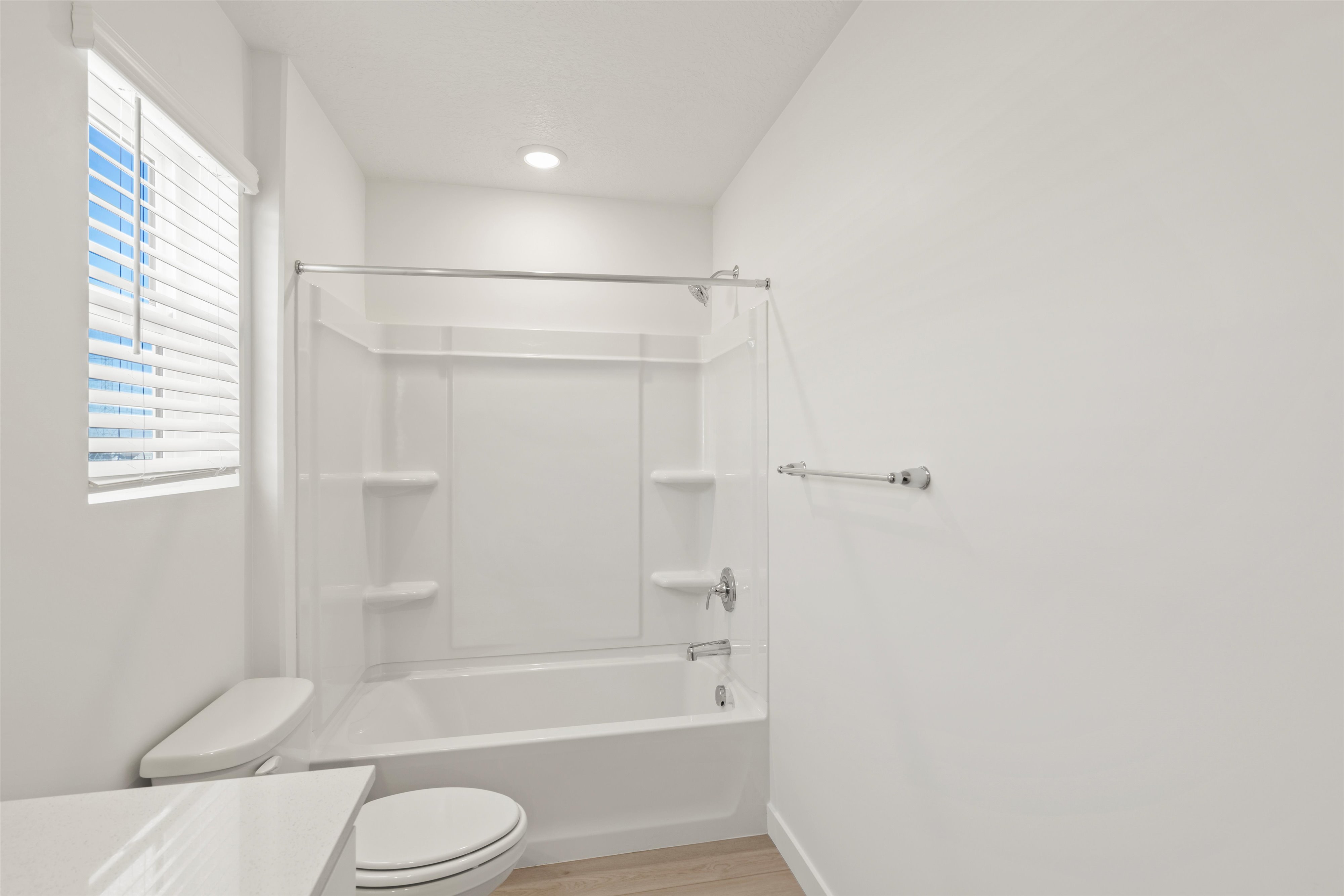 **DISCLAIMER** Interior package may vary. Full bathroom featuring a white tub/shower combination with integrated shelving, chrome fixtures, and a recessed ceiling light