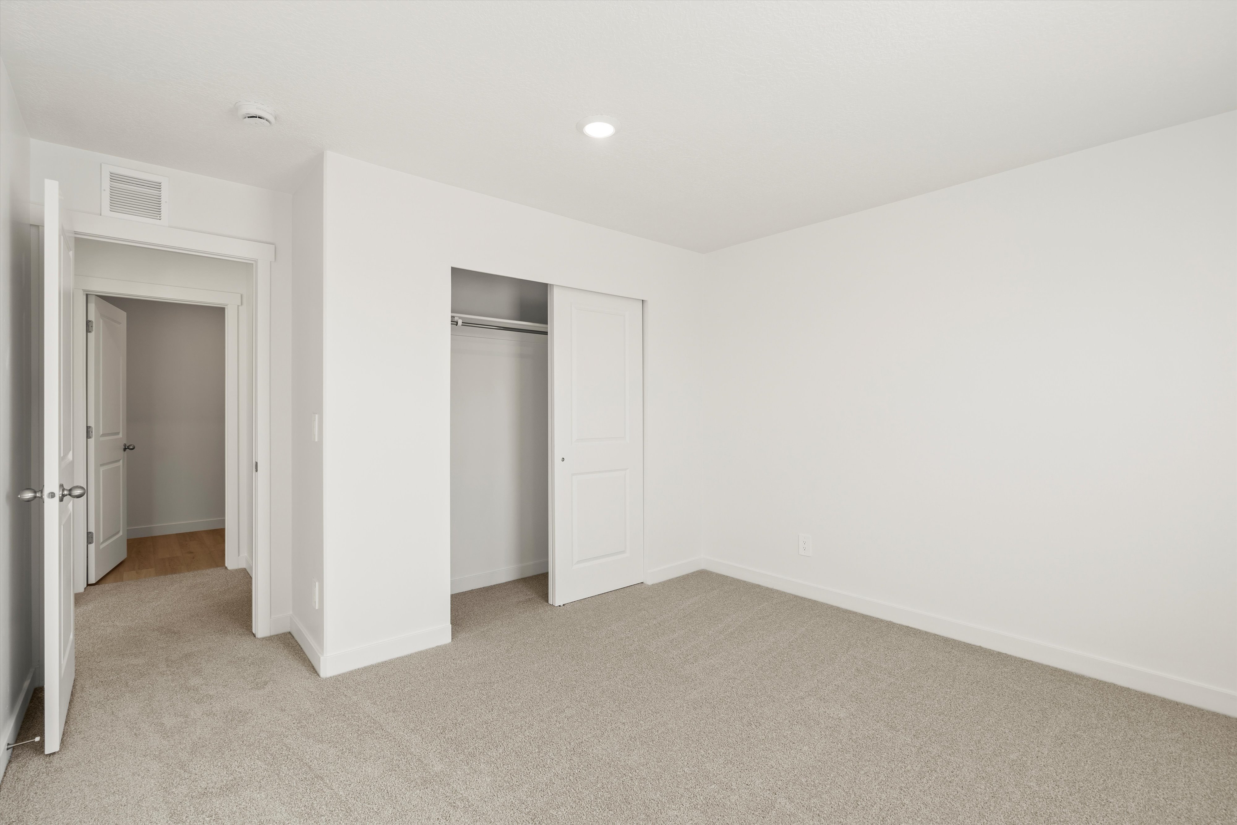 **DISCLAIMER** Interior package may vary. Bedroom featuring carpet flooring, white walls, and a closet with sliding doors