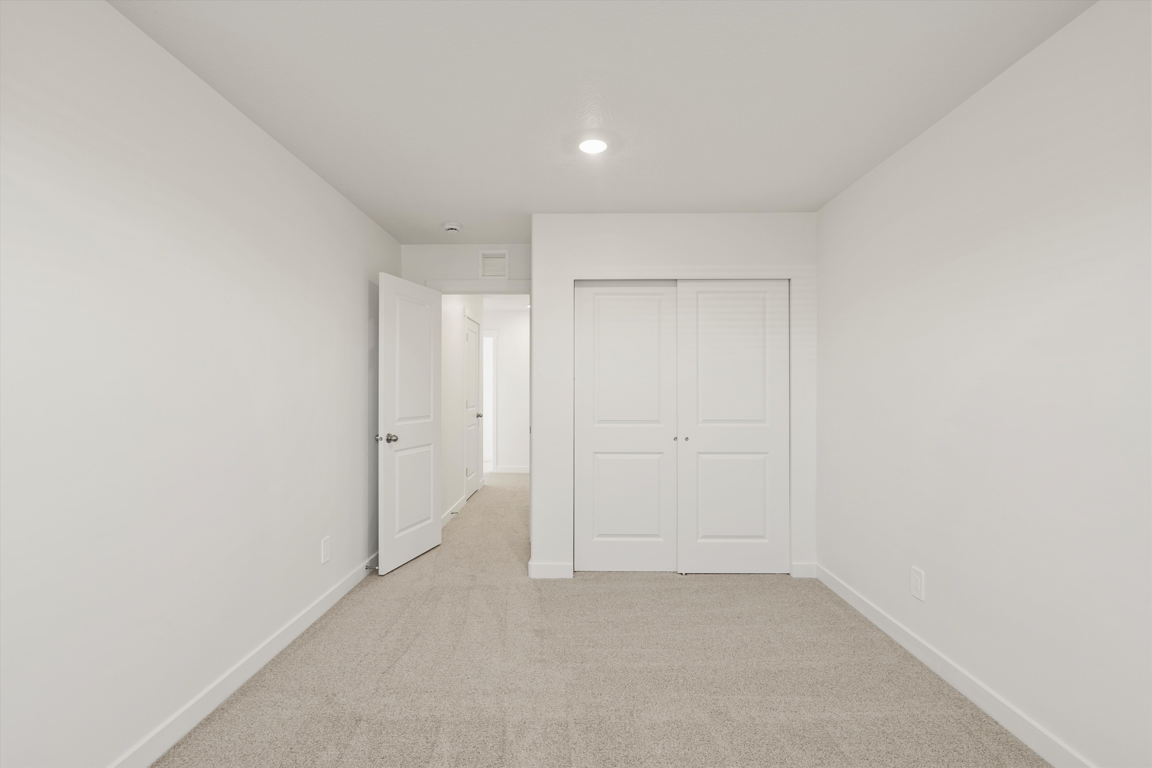 **DISCLAIMER** Interior package may vary. Carpeted room featuring a white interior door, white bi-fold closet doors, white baseboards, and a recessed ceiling light