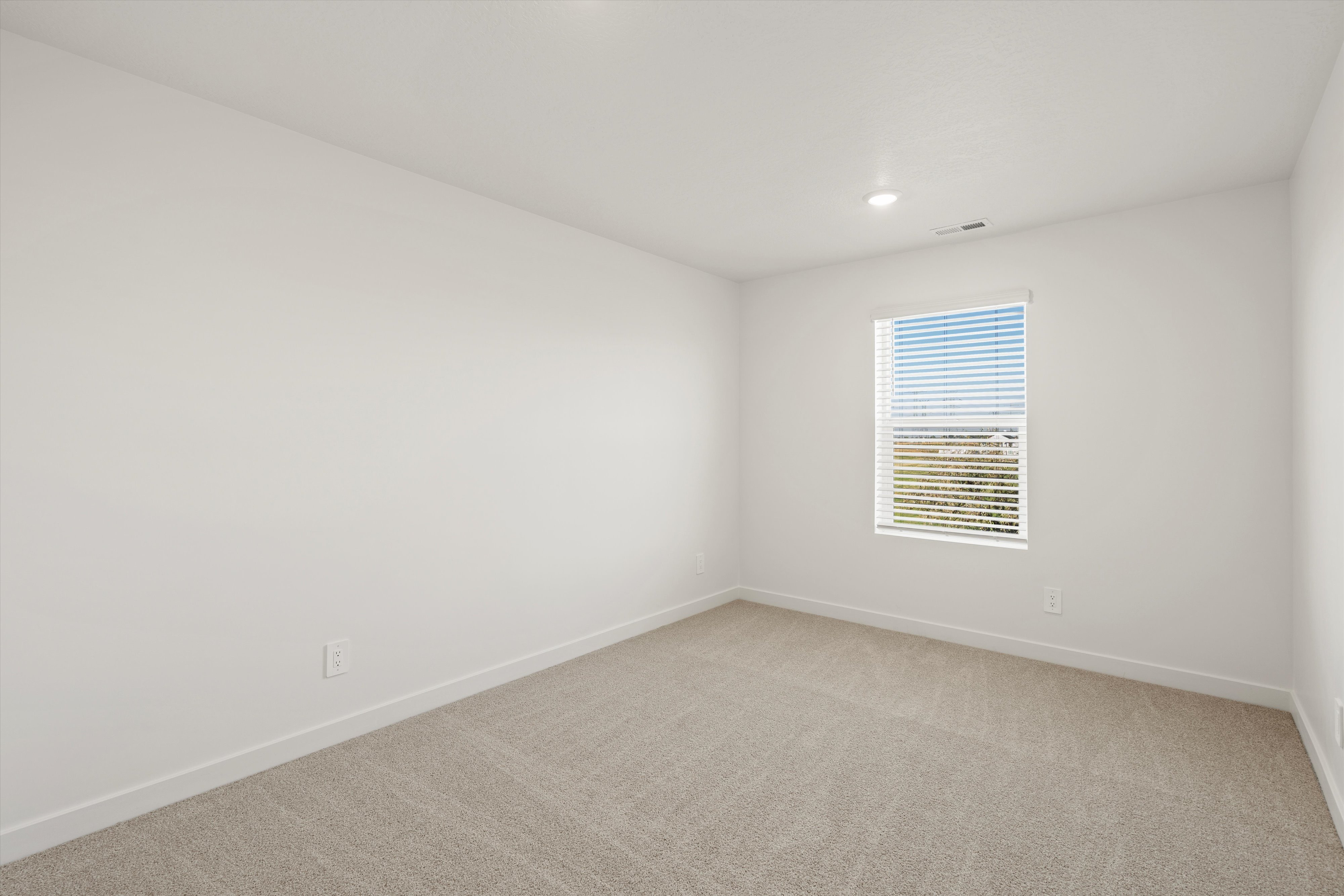 **DISCLAIMER** Interior package may vary. Bright room featuring a single window with horizontal blinds, neutral carpeting, white baseboards, and recessed ceiling lighting