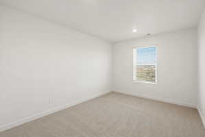 **DISCLAIMER** Interior package may vary. Bright room featuring a single window with horizontal blinds, neutral carpeting, white baseboards, and recessed ceiling lighting