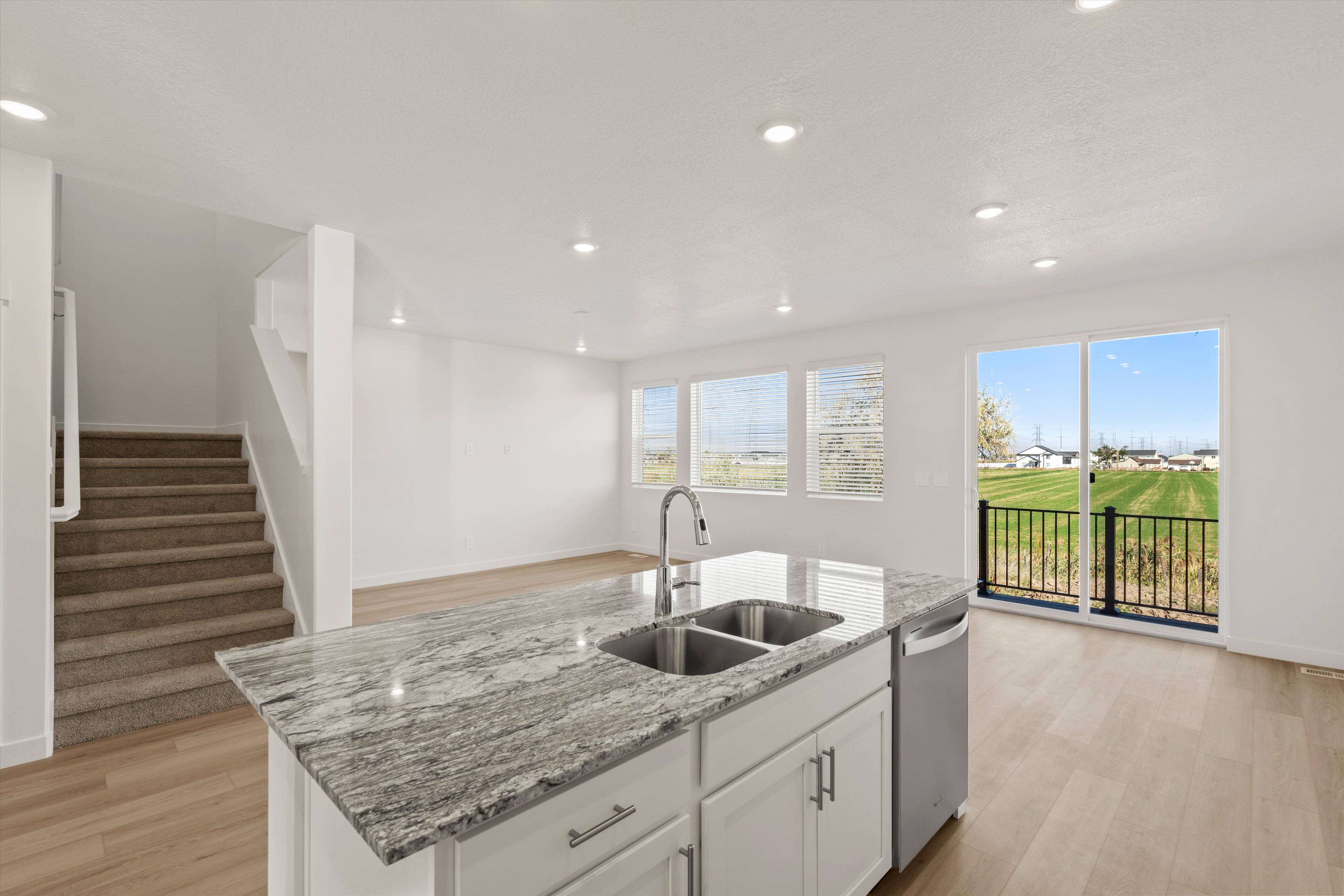 **DISCLAIMER** Interior package may vary. Kitchen island with a dual stainless steel sink and granite countertop