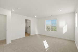 **DISCLAIMER** Interior package may vary. Carpeted room featuring a large window with horizontal blinds, recessed ceiling lighting, and crisp white walls