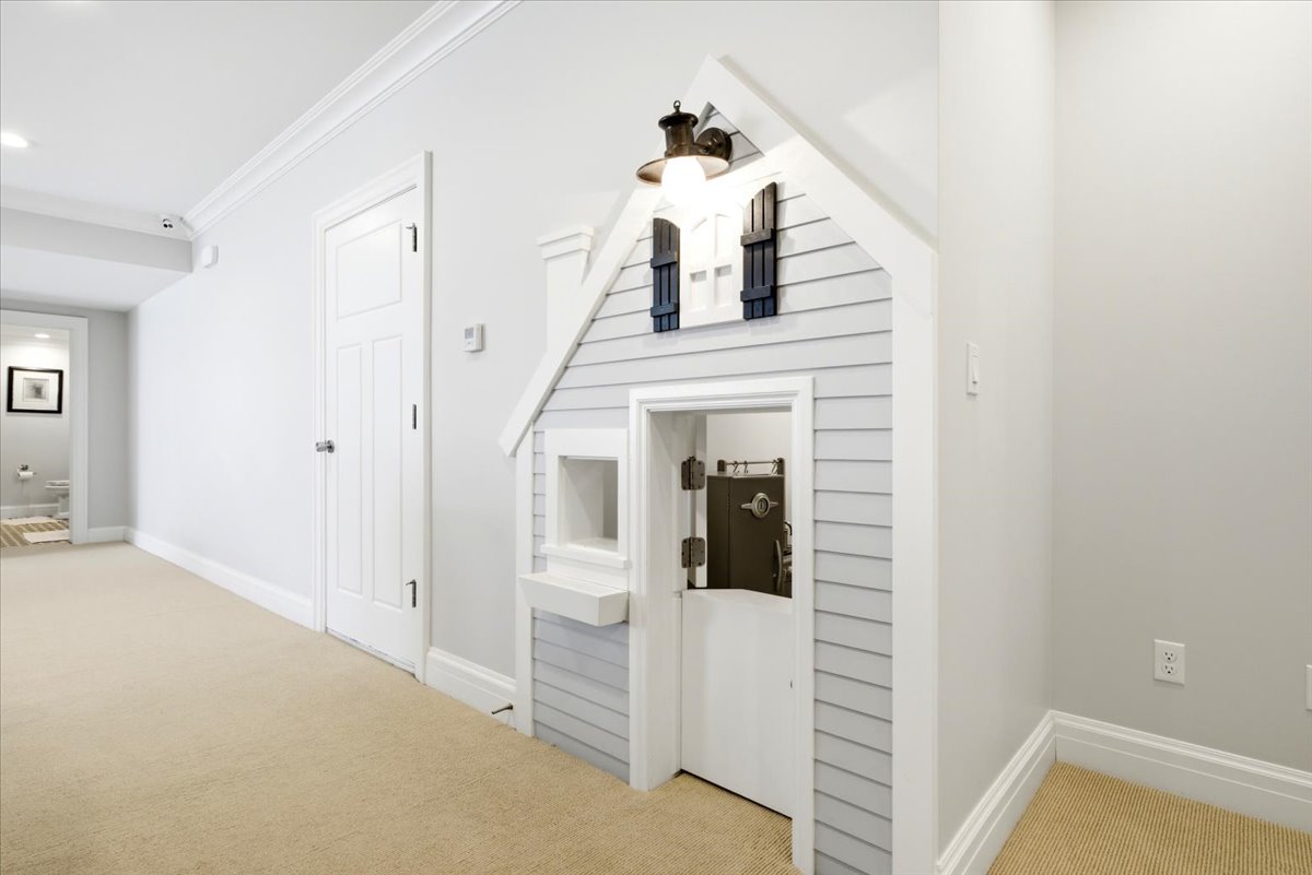 Hallway featuring a built-in playhouse with shiplap siding and decorative shutters