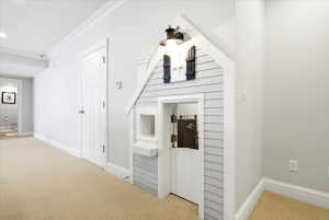 Hallway featuring a built-in playhouse with shiplap siding and decorative shutters