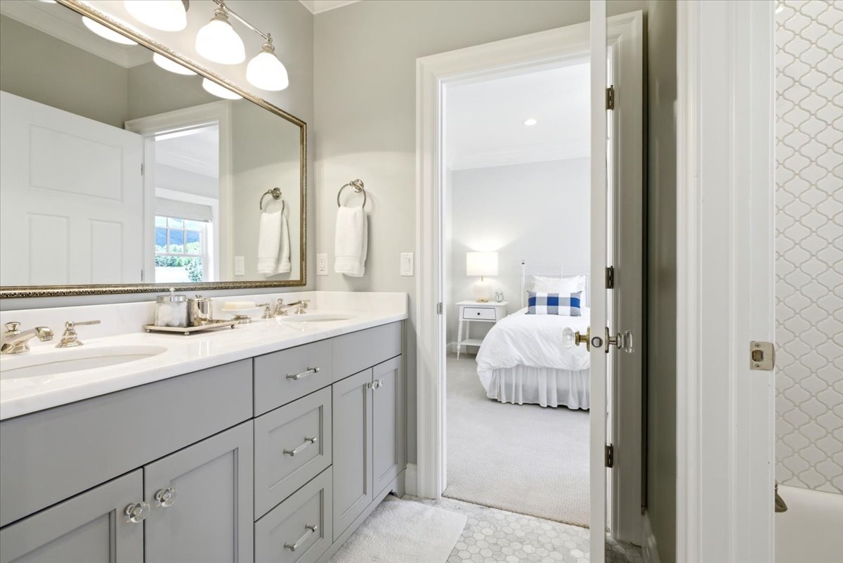Double vanity featuring gray cabinetry, polished chrome hardware, and a white countertop