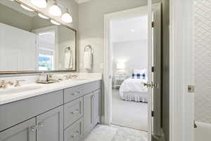 Double vanity featuring gray cabinetry, polished chrome hardware, and a white countertop