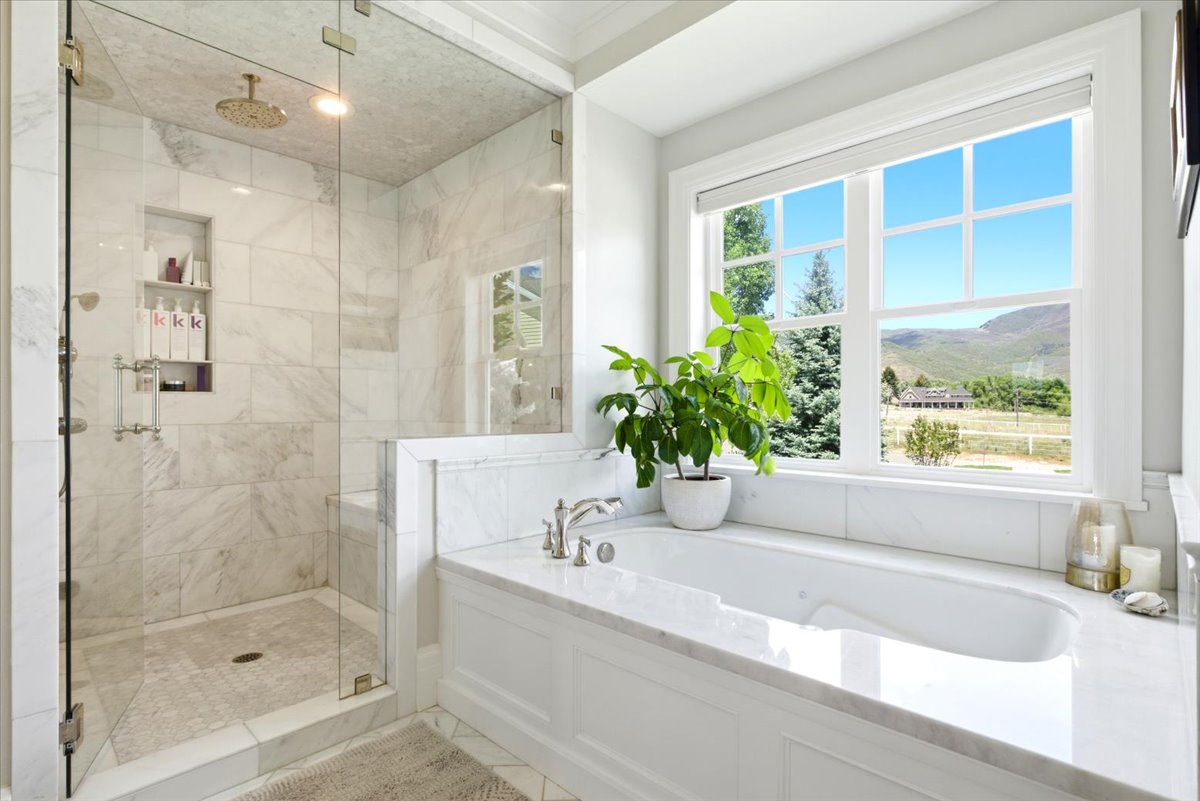 Spacious bathroom featuring a large window with a mountain backdrop