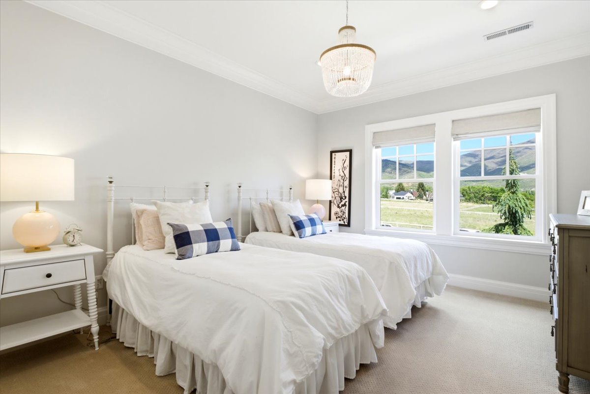 Bright bedroom featuring two large windows with amazing views