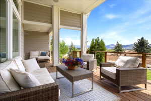 Expansive covered deck featuring a wood-finish floor, wood railing with horizontal metal balusters, and a beige horizontal siding exterior