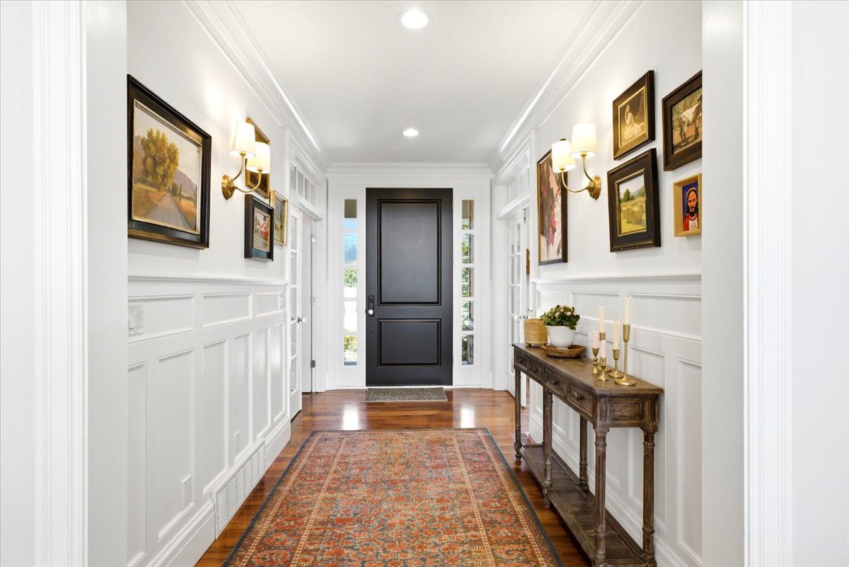 Entryway featuring wainscoting and crown molding