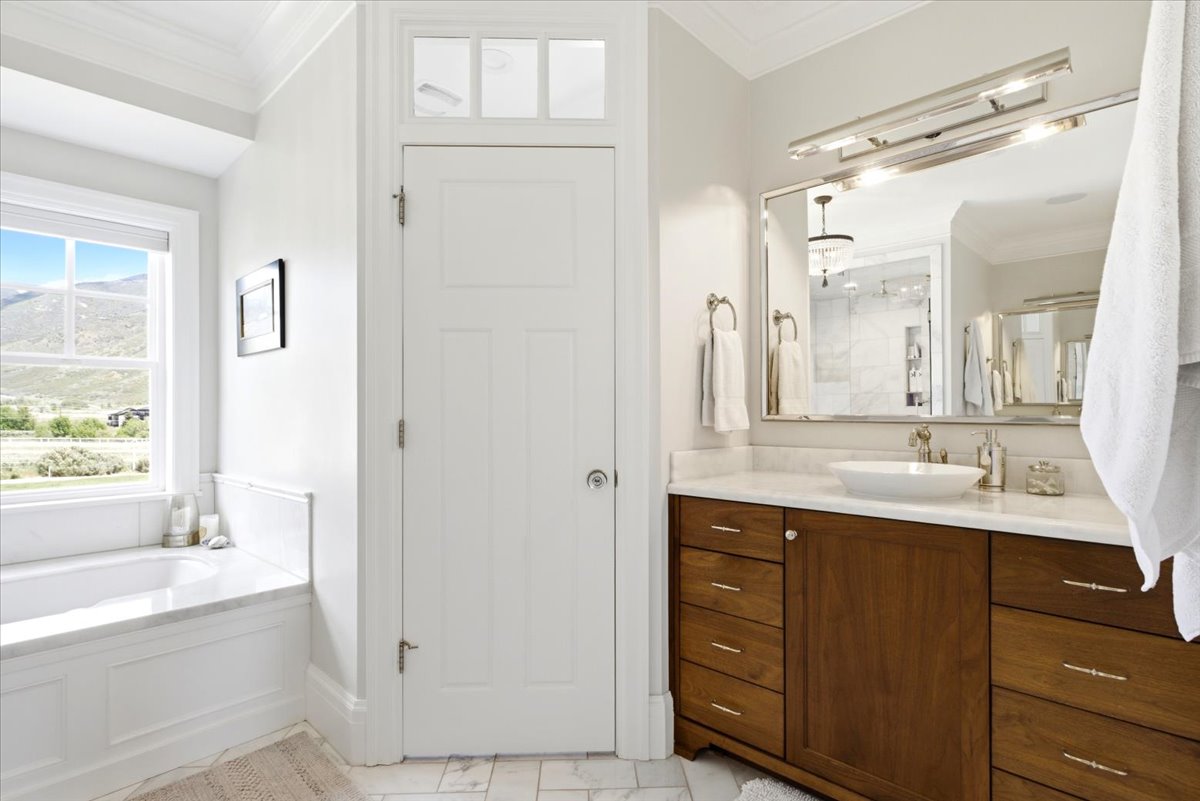 Master Bathroom featuring a wood-finish double vanity with a marble countertop and a vessel sink