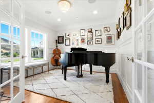 Room featuring hardwood flooring, white wainscoting, and a decorative ceiling light fixture