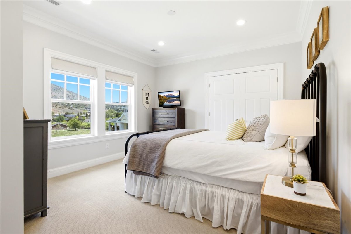 Bright bedroom featuring dual double-hung windows with roller shades
