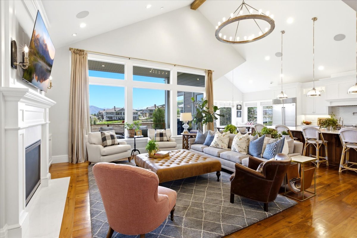 Vaulted ceilings featuring an exposed wood beam and a circular chandelier