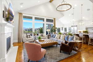 Vaulted ceilings featuring an exposed wood beam and a circular chandelier