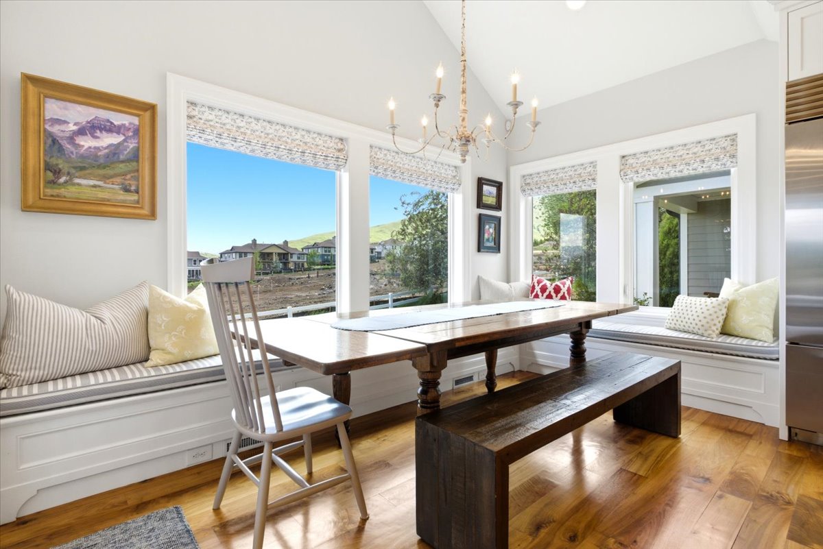 Dining area featuring a vaulted ceiling with a chandelier, and multiple large windows