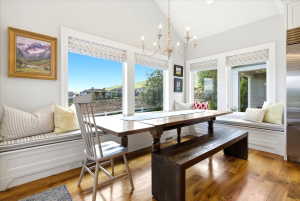 Dining area featuring a vaulted ceiling with a chandelier, and multiple large windows