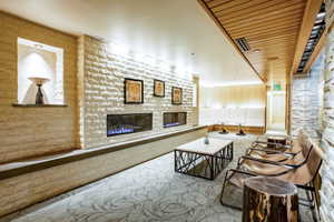 Stone-clad accent wall featuring two linear fireplaces and a built-in display nook