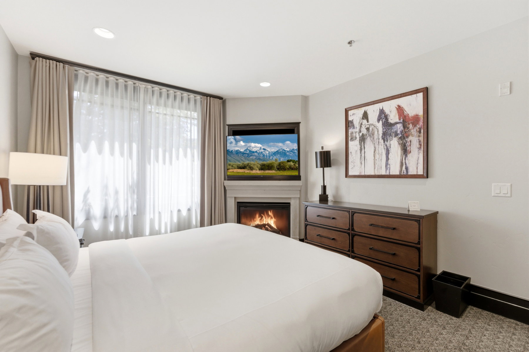 Corner fireplace with mantel, featuring an integrated television above