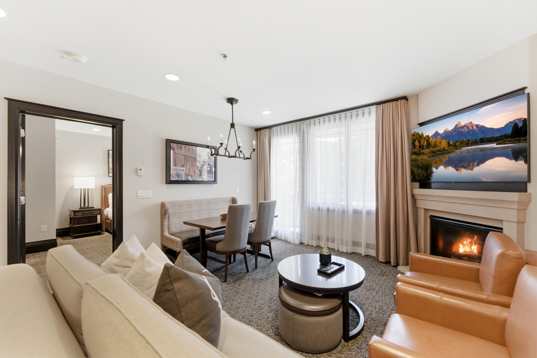 Open-concept living area with a built-in fireplace, recessed lighting, and a chandelier-style fixture above the dining area