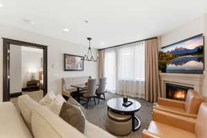 Open-concept living area with a built-in fireplace, recessed lighting, and a chandelier-style fixture above the dining area