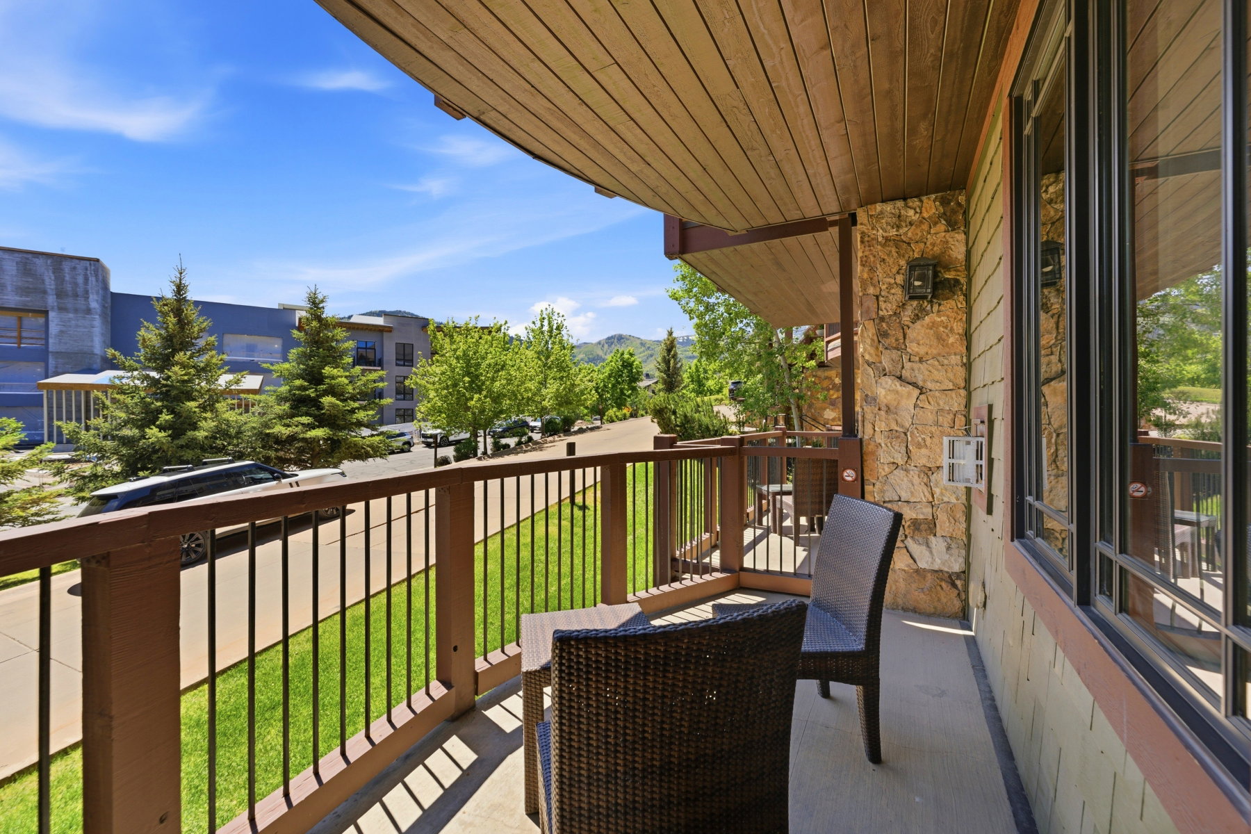 Private balcony with stone accent wall and natural wood ceiling