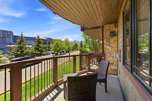 Private balcony with stone accent wall and natural wood ceiling