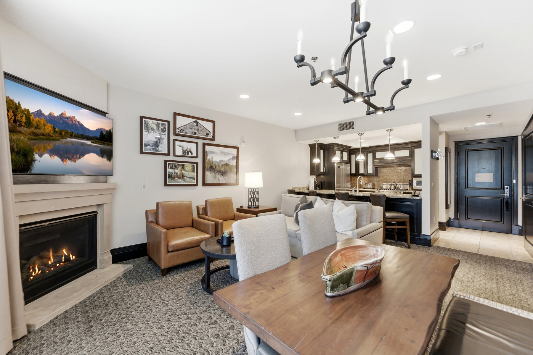 Living area featuring a gas fireplace with a stone surround, recessed lighting, and a chandelier