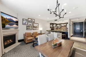 Living area featuring a gas fireplace with a stone surround, recessed lighting, and a chandelier