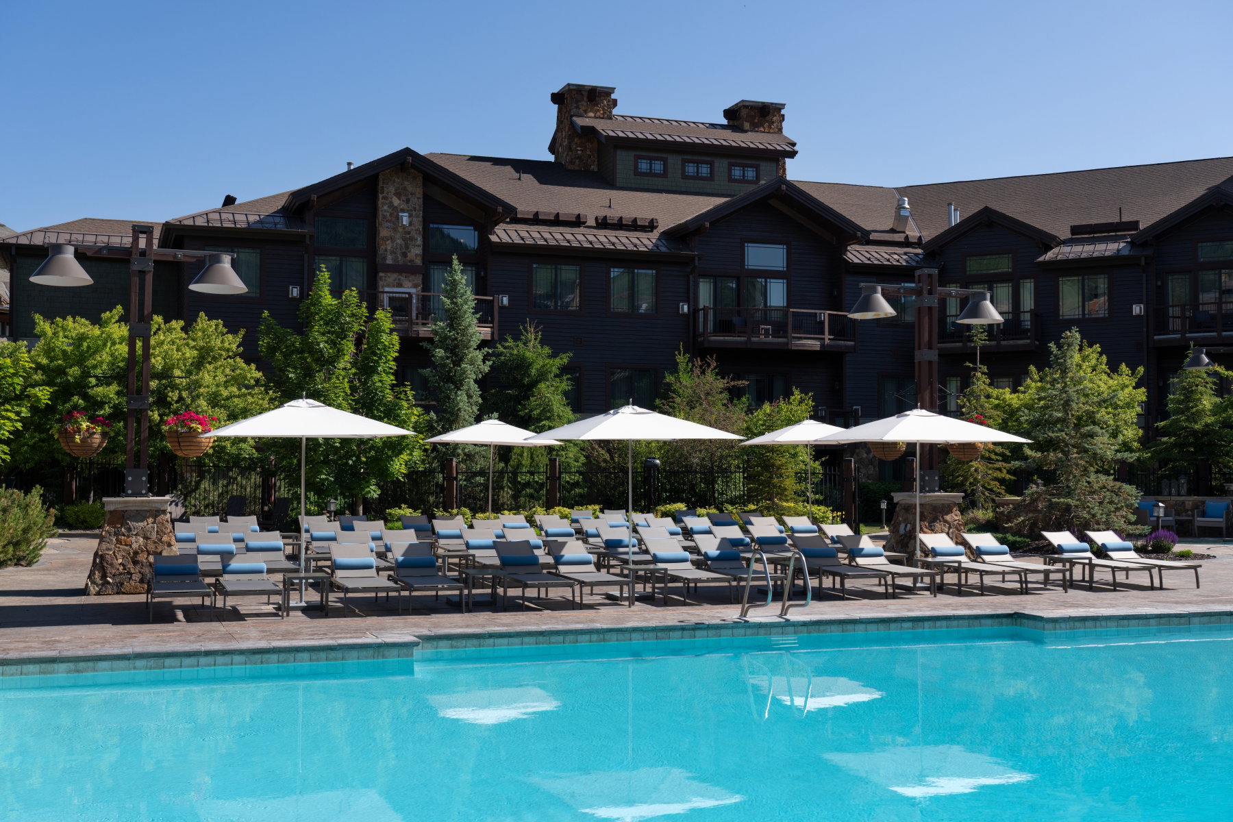 Expansive outdoor swimming pool with surrounding lounge chairs and white umbrellas