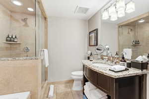 Bathroom featuring a glass-enclosed shower with recessed lighting and a built-in shelf