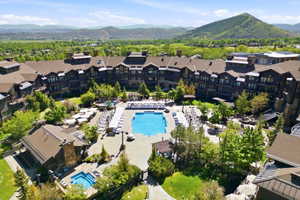 Expansive outdoor amenity space featuring a large swimming pool, multiple lounge areas, a separate spa, and surrounding green spaces