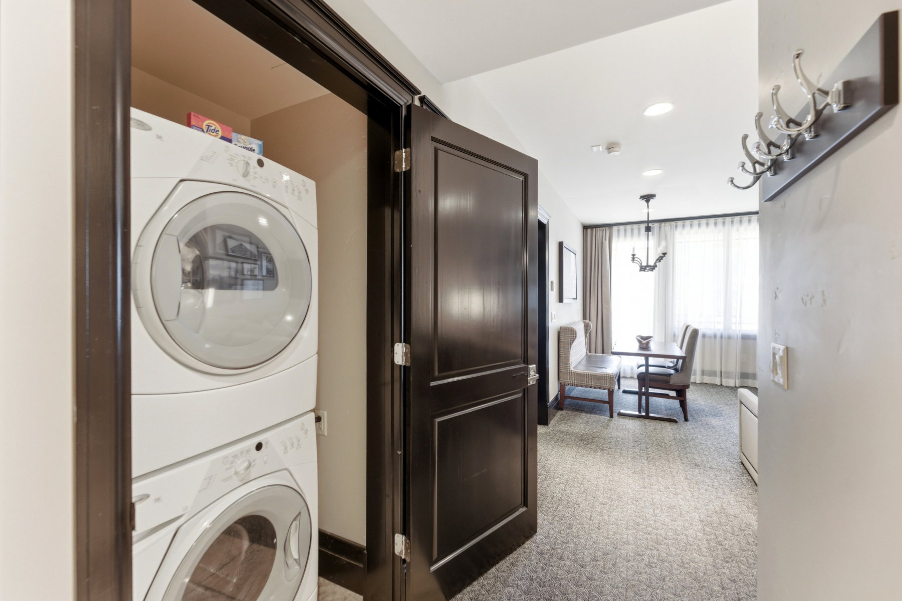 Recessed laundry closet featuring stacked front-load appliances